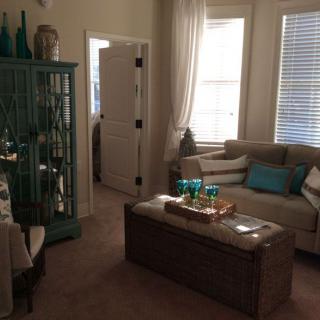 A cozy living room with a sofa, decorative pillows, and a stylish cabinet.