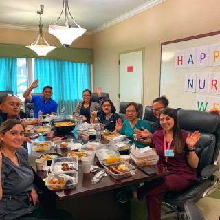 Group of nurses celebrating with a meal during Nurses Week in an office setting.
