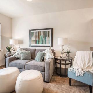 A cozy and modern living room with a gray sofa, blue armchair, and stylish decor.