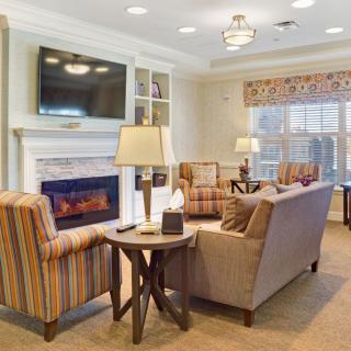 A cozy living room with a fireplace, comfortable seating, and a large TV.