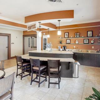 A modern kitchen interior featuring a central island with bar stools and stylish lighting.