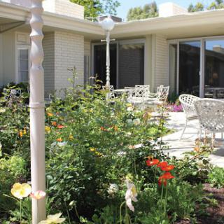 A beautiful garden patio with vibrant flowers and comfortable seating.
