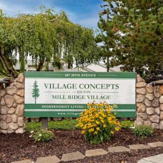 Entrance sign for Village Concepts, a residential community featuring beautiful landscaping and flowers.