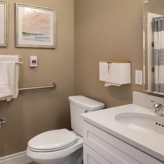 A neatly designed bathroom with a toilet, sink, and mirror.