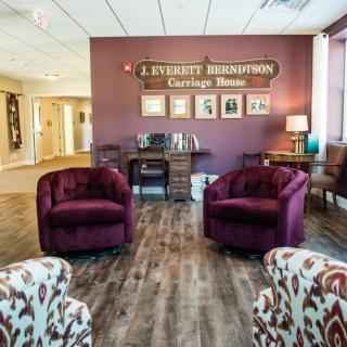 A cozy lobby with comfortable seating and decorative signage on a purple wall.
