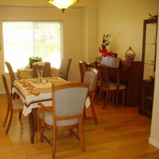 A dining room with a wooden table and chairs, featuring a cabinet and decorative items.