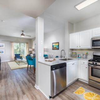 A modern open-concept kitchen and living room with sleek appliances and vibrant decor.