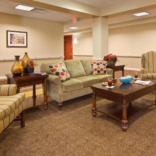 A cozy living room setup featuring a sofa, two chairs, and a coffee table, complemented by decorative vases.