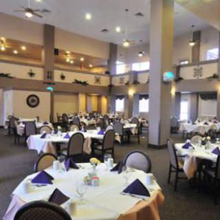 A spacious banquet hall with elegantly set round dining tables, ready for an event.