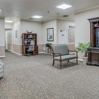 A spacious lobby with comfortable seating, decorative plants, and a bookshelf.