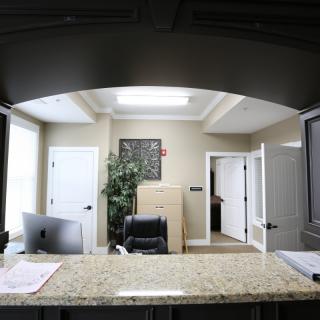 A modern office reception area with a desk and computer.