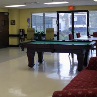 A community game room featuring a pool table and seating area.