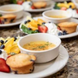 A delectable breakfast spread featuring crme brle, muffins, and fresh fruit.