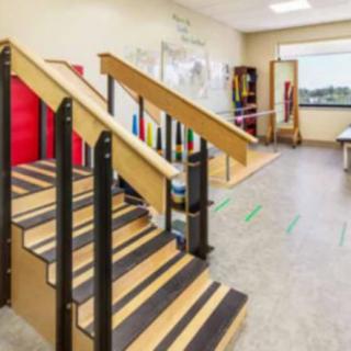 A rehabilitation room featuring therapy stairs and various equipment.