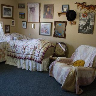 A cozy bedroom with vintage decor, featuring a single bed and wall art.