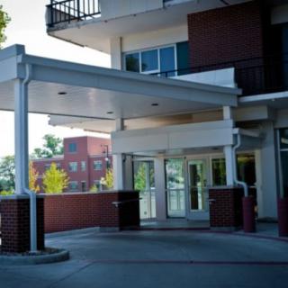 A modern building entrance with glass doors and overhead covering.