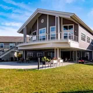 A modern residential building with a spacious lawn on a sunny day.