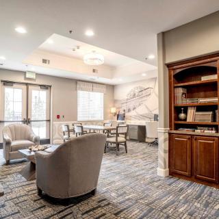 A cozy lobby with comfortable seating and a built-in bookshelf.