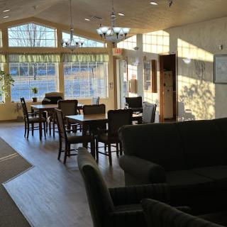 A bright and inviting dining area with ample natural light, featuring tables and comfortable seating.