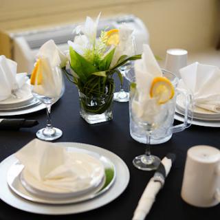 An elegantly set dining table featuring fresh flowers and meticulously arranged napkins.