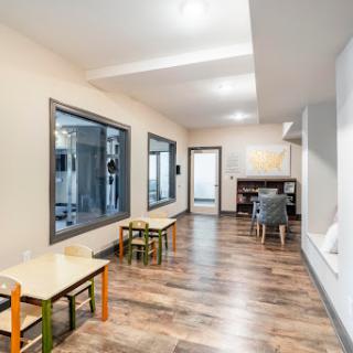 A bright and spacious playroom featuring colorful furniture, designed for child-friendly activities.