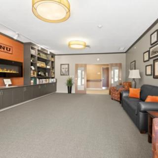 A modern lobby area with comfortable seating and a well-organized bookshelf.