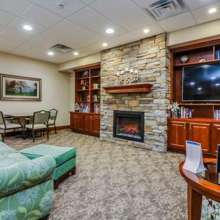 A cozy living room with a stone fireplace, television, and comfortable seating.