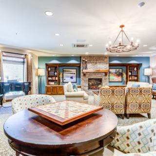 A cozy living room with elegant furniture, a fireplace, and a chandelier.