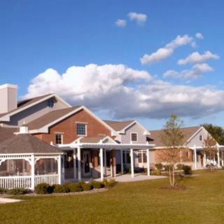 A picturesque residential building under a clear blue sky with scattered clouds.