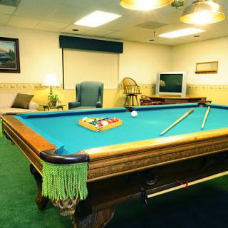 A cozy game room featuring a billiards table ready for a match.