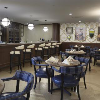 A cozy restaurant interior with neatly set tables and a bar area.