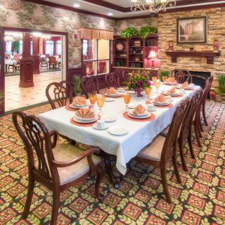 An elegantly set dining room with a long table, ornate chairs, and classic decor.