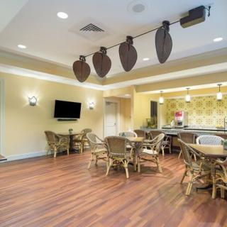 A cozy lounge area with wooden floors, comfortable seating, and a mounted television.