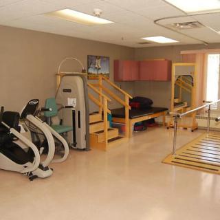 A physical therapy room equipped with exercise machines and rehabilitation tools.