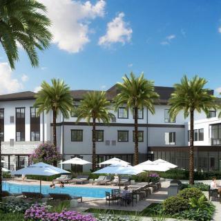 A luxurious resort with a swimming pool surrounded by palm trees and outdoor seating.
