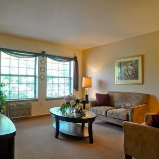 A cozy living room with a large window, comfortable seating, and elegant decor.