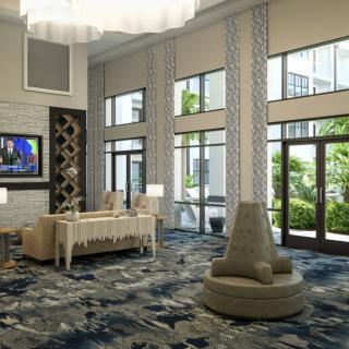 Modern lobby area with stylish furniture and large windows offering a view outside.