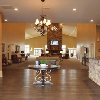 A spacious lobby with elegant decor and a central chandelier.