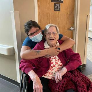 A joyful moment between a caregiver and an elderly resident, sharing smiles and warmth.