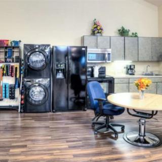 A multipurpose room featuring laundry and kitchen appliances with a seating area.