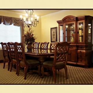 A traditional dining room with an elegant wooden table and chairs, adorned by a chandelier.