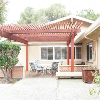 A cozy patio area with a pergola providing shade and outdoor seating.