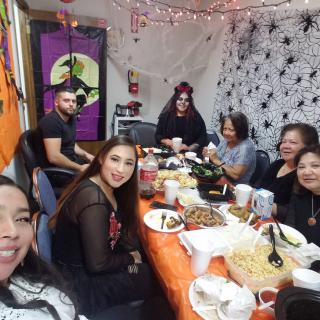 A group of people enjoying a Halloween-themed party with festive decorations and food.
