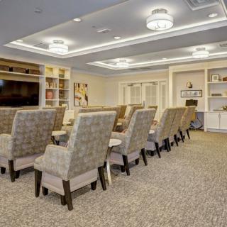 A modern conference room with comfortable seating and a large television.