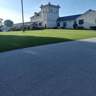 A well-maintained property featuring a distinctive architectural building, surrounded by lush green grass.