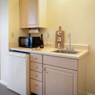 A compact kitchen area with a sink, microwave, and mini fridge.