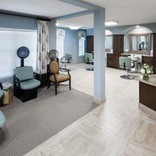 A modern salon interior with styling chairs, mirrors, and hair dryers.