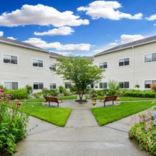 A serene courtyard with benches and pathways surrounded by a well-maintained garden.