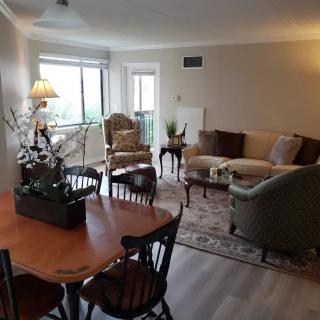 A cozy living room and dining area featuring elegant furniture, a sofa, chairs, and a coffee table.