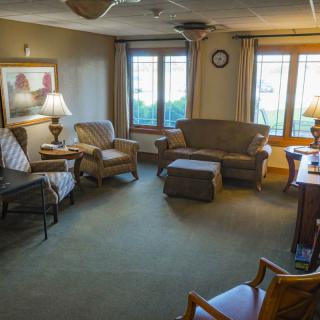 A cozy living room with comfortable seating and natural light from large windows.